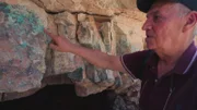 Der jordanische Archäologe Mohammad Najjar zeigt auf ein Gebiet in einer ehemaligen Kupfermine in Wadi Faynan, Jordanien.