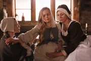 Bei Geburten müssen sich Anna Stein (Julia Thurnau, re.) und ihre Gehilfin (Elina Vaska, li.) auf ihre Erfahrung und das Gefühl in ihren Händen verlassen. Mit routinierten Griffen wird die Lage des Kindes in Johannas (Maija Arvena, Mi.) Bauch ertastet.