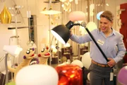 Jan und Henry holen sich Rat bei einer Verkäuferin (Esther Brandt) in einem Lampenladen.
