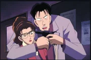 Eri (l.) wollte Kogoro eigentlich nur frische Kleidung bringen, als sie plötzlich von Murakami (r.) als Geisel genommen wird. Doch was hat er vor?