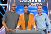 Quizmasterin Esther Sedlaczek M.) mit den Kandidaten vom Team "Gold" Julian Weber (Speerwurf-Europameister) und Richard Ringer (Marathon-Europameister, v.l. am Panel)