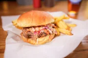 Pulled-Pork-Sandwiches werden bei „Martin’s BBQ“ frisch serviert, nachdem ein ganzes Schwein 24 Stunden lang auf dem hauseigenen Räucherofen geröstet wurde.