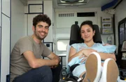 Eine Sturzgeburt mitten auf dem Parkplatz eines Baumarktes fordert die ungeteilte Aufmerksamkeit des Rettungsteams. Leonies (Acelya Seze, r.) Wehen haben auf dem Parkplatz begonnen. Lukas (Arda Görkem, l.) und Leonie sitzen nach der Geburt gesund im RTW.