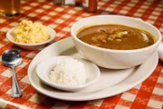 Hähnchenwurst-Gumbo mit Reisbeilagen und Kartoffelsalat, serviert im „Prejeans“, außerhalb von Lafayette, Louisiana.