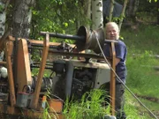 Stan Zuray using the winch he built out of salvaged parts to coax his fish wheel into the Yukon River.