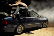 Episode Down Power Lines. Bear Grylls climbing out of the car that is electrically charged.