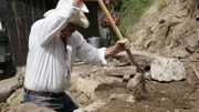 Marty Raney digging with shovel.