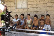Camera person filming village children.