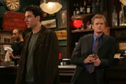 Bei einem gemeinsamen Bar Besuch mit Barney (Neil Patrick Harris, r.) lernt Ted (Josh Radnor, l.) die hübsche Fernsehreporterin Robin kennen und ist wie verzaubert von ihr ...