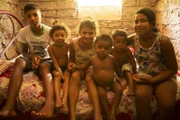 Village children sitting in their home.