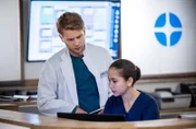 Dr. Mikko Rantala (Luan Gummich, l.) korrigiert Assistenzärztin Sofia Galura (Olivia Papoli-Barawati, r).