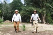 L-R: Misty Bilodeau and Nicholas Babbit walking in a dirt field.
