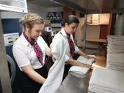 Hotelpraktikantin Alina Meinhard faltet mit der 2. Hotelmanagerin Claudia dos Santos Tischdecken.