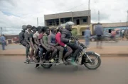 Auf der neuesten Schöpfung von Motorradmechaniker Emmanuel (re.) haben neun Personen Platz. Überall dort, wo es für herkömmliche Fahrzeuge zu eng wird, zeigen seine Maschinen ihre Stärke.