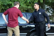 Norman and police officer shaking hands.