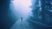 Silhouette einer Person auf der Straße in der Dunkelheit
