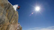 Skier in midair on snowy mountain