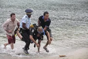 Phil Owen (Sean Gallagher, l.), Dwayne (Danny John-Jules, 2.v.l.) und Mark Lightfoot (O-T Fagbenle) tragen den leblosen Körper von Benjamin Lightfoot (Alex Lanipekum) aus dem Meer. Phil Owen (Sean Gallagher, l.), Dwayne (Danny John-Jules, 2.v.l.) und Mark Lightfoot (O-T Fagbenle) tragen den leblosen Körper von Benjamin Lightfoot (Alex Lanipekum) aus dem Meer.