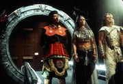 Yu (Vince Crestejo, li.), Nirrti (Jacqueline Samuda) und Cronos (Ron Halder) erreichen durch das Stargate die Erde. Sie sind Abgesandte der Systemlords und wollen mit den Menschen und den Asgards verhandeln.