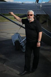 Bruce Pearson, whose father allegedly was taken to the site of the Dark Pyramid in Alaska, in front of a plane