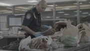 Die CBP-Beamten Islam und Hundal inspizieren mit Messern die Kisten eines Passagiers und suchen nach Zollverstößen am Dulles International Airport in Dulles, Virginia (National Geographic).