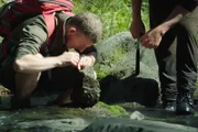 Der Geologe Julian Thomson (li.) untersucht Fossilien im Flussbett des Maungataniwha Native Forest, einem entlegenen Gebiet, in dem einst Dinosaurierknochen gefunden wurden.