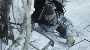Hazen Audel carefully climbs a steep snow cliff using only his hands and feet.