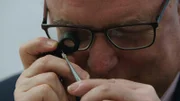 Ein Mann begutachtet einen Diamanten