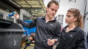 Femi (Spencer König) lauscht wie Kiras Konkurrentin Tomke (Sophie Stern, re.) von Trainer Olaf (Tobias Schönenberg) eingenordet wird.