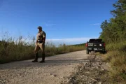 Warden Jake Noxon standing behind his truck.