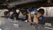 Die CBP-Beamten Thomas, Rodriguez und Vasquez arbeiten gemeinsam daran, die Unterseite des Fahrzeugs eines Verdächtigen zu zerlegen, um geschmuggelte Drogen in Pharr, Texas, zu bergen.