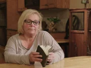 Cindy Moore looking through mom?s devotional book during interview.
