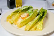 Als Anspielung auf sein Originalrezept wird der Caesar Salad bei „Romesco’s“ in Bonita, Kalifornien, am Tisch zubereitet.