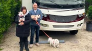 Eine Frau und ein Mann stehen mit Hunden