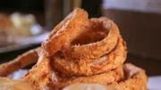 Hausgemachte Zwiebelringe, serviert im Copper Penny in Wilmington, North Carolina, zu sehen in Diners, Drive-Ins and Dives Folge 2808.