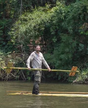 Hazen Audel travels on a bamboo raft down a river.