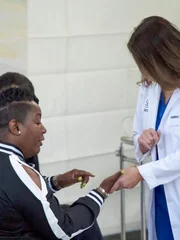 Dr. Sandra Lee examines Erica L. right hand palm with the pencil lead.
