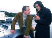 Dahlen (Andreas T. Möckel) will von Engelhardt (Charlotte Schwab), die ihn versehentlich angefahren hat, ins Krankenhaus gefahren werden.