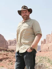 Josh Gates poses in front of stunning rock formations at Arches National Park, Utah, as seen on Travel Channel's Expedition Unknown.