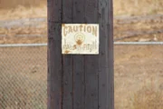 A sign on a wooden post, warning against unexpected throwing axes with the words: "CAUTION, AXES-IN-FLIGHT."