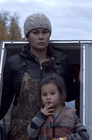 Courtney Agnes slows the boat when she thinks she has spotted a good hunting spot, while her daughter Carrie Agnes chews on her finger nails.