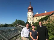 Von links: Patrick Lindner, Steffi Gehrlein zusammen und einem Mönch des Benediktinerstifts Göttweigs im Marillengarten des Stifts.