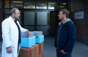 Sebastian Klöckner (Matthi Faust, r.) erfährt von dem Apotheker Robert Kleber (Andreas Schröders, l.), dass er die Arztpraxis der Ermordeten regelmäßig mit Medikamenten versorgt hat.