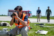 Brantford, Ontario, Canada - A Crash Investigator begins to take pictures of the scene of the crash as Investigator Echeverri and an Air Force Officer arrive to make preliminary observations. (Cineflix 2019/Darren Goldstein)