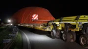 Spektakuläre Manöver auf Autobahn und Landstraße: Ein Schwertransporter transportiert einen riesigen Flugsimulator für Flugbegleiter zum Trainingscenter.