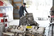 An AIB investigator begins sorting wreckage as a reconstruction of the plane gets underway.