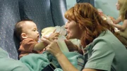 RE-ENACTMENT STILL:  Nurse and baby ready for the flight.