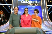 Quizmasterin Esther Sedlaczek (M.) mit den Kandidat:innen des Teams "Ku'damm":  Ulrich Noethen (l.), Schauspieler und Emilia Schüle (r.), Schauspielerin.
