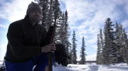 Michael Manzo untersucht Karibu-Spuren auf dem verschneiten Weg. (National Geographic/John Griber)