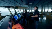 Expedition crew members stand in the bridge, overseeing operations in search of the USS Indianapolis.